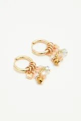 Aros dorados tipo argolla con dijes colgantes de cuentas de vidrio en tonos beige y verde.