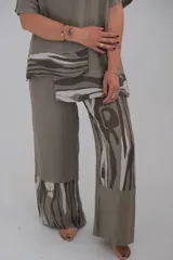 Pantalón de lino color visón, de corte recto y tiro alto, con apliques de tela estampada en tonos grises y blancos.