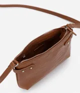 Bolso bandolera pequeño color marrón con textura de piel de cocodrilo, correa fina ajustable, cierre de cremallera y hebillas laterales decorativas.