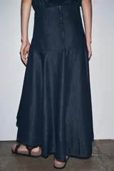 Falda midi de denim azul oscuro, de tiro medio, corte evasé y cierre trasero con cremallera metálica.