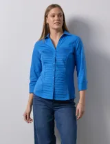 Camisa blanca de algodón marca Zac & Rachel, con cuello con solapa, abertura central con botones, delantera tableada y laterales elastizados.