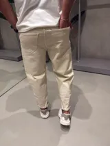 Jean slouchy color arena, de corte holgado y tiro alto, con bolsillos laterales y traseros.