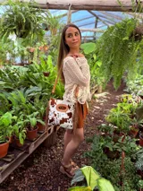 Bandolera de cuero con estampado animal print de vaca en tonos marrón y blanco, con flecos de cuero marrón en los laterales. Tiene correa larga de cuero marrón regulable y asa de mano con forma ovalada.