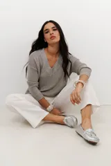 Sweater de tejido de punto fino con brillo metálico, color verde lima. Presenta escote en V y mangas largas.