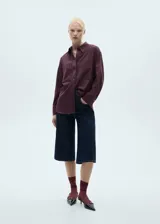 Abrigo color borgoña con estampado de raya diplomática, corte recto, cuello camisero y diseño oversize.