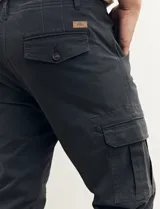 Pantalón de gabardina color marrón, corte slim fit, con bolsillos laterales tipo cargo.