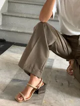 Sandalias de cuero color beige con dos tiras finas en el empeine, tira al tobillo con hebilla y tacón cuadrado de madera.