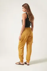 Pantalón jogger negro de nylon con elástico ancho en la cintura, puños elásticos ajustables y lazos laterales para fruncir.