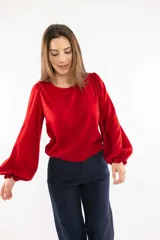 Blusa azul marino con cuello bote y mangas amplias con elástico en los puños.