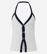 Top de tejido rib blanco, ajustado al cuerpo, con escote profundo y cuello halter. Presenta un ribete contrastante azul marino en el escote y a lo largo del cierre frontal de botones.