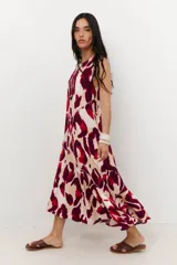 Vestido midi sin mangas, con cuello redondo, estampado animal print en tonos rojo, bordó y beige. Presenta cortes diagonales en el cuerpo que añaden estructura al diseño.