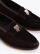 Mocasín de cuero vacuno con efecto gastado en tonos grises y negros. Presenta un aplique metálico con el logo Fire en la vincha y suela grabada con el nombre de la colaboración.