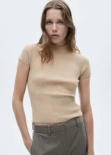 Remera color beige de punto fino con cuello perkins y mangas cortas.