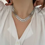 Collar plateado con eslabones formados por flores y cuadrados calados.