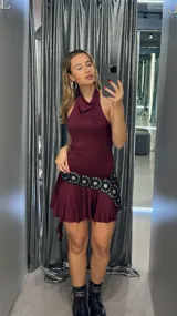 Minivestido marrón con cuello halter, falda con volados y cinturón con tachas.