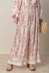 Pantalón palazzo de poliéster con estampado floral en tonos beige y rosa, cintura elastizada y corte plisado.