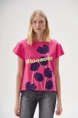Remera fucsia de algodón con estampado de flores color azul y texto 'Blossom' en amarillo.