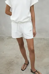 Shorts blancos de algodón orgánico y reciclado, con cintura elástica ajustable y bolsillos laterales.