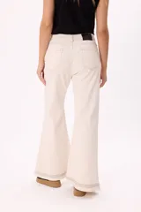 Pantalón jean de denim azul oscuro, corte wide leg, tiro medio y costuras a la vista en color ocre.