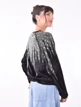Campera negra de terciopelo con cierre frontal y apliques de lentejuelas plateadas.