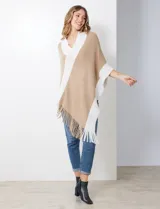 Poncho de tejido soft, color beige y blanco, con diseño cruzado en el frente y cuello en V. Presenta bordes y flecos en color blanco.