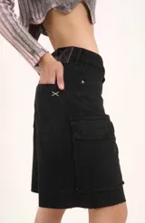 Bermuda de denim azul de tiro bajo, con múltiples bolsillos cargo en los laterales y terminación de ruedo deshilachada.