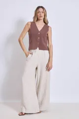 Chaleco de punto sin mangas, color rosado, con escote en V y cierre frontal de tres botones marrones.