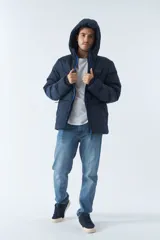 Campera puffer azul marino para hombre, con capucha ajustable, cuello alto, bolsillos con cierre y logo en goma.