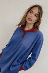 Buzo azul de algodón con cuello polo rojo con botones y puños acanalados.