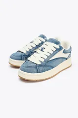 Zapatillas deportivas de denim azul con detalles en cuero sintético blanco.