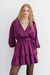 Vestido corto color violeta con estampado de corazones, escote cruzado, mangas largas abullonadas y cintura elastizada.