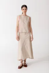 Blusa color ladrillo de lino 100% con cuello redondo y sin mangas. Presenta vivos y pespuntes a contratono en color marrón.