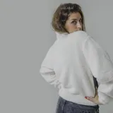 Buzo verde militar de sherpa con corte a la altura del pecho en tela lisa y cierre con cremallera amarilla.