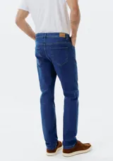 Pantalón de jean de corte slim, color azul oscuro, con elastano. Diseño clásico con bolsillos delanteros y traseros.