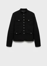 Chaqueta negra con cuello mao y cierre frontal con botones dorados. Tiene cuatro bolsillos de parche con solapa y botón.