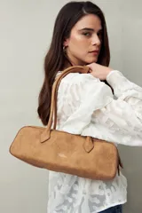 Cartera baguette color marrón claro, confeccionada en símil cuero con formato cilíndrico y doble asa corta.