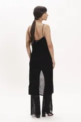 Pantalón palazzo de punto calado negro, con cintura elástica y corte acampanado.