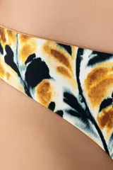Calzón de bikini de corte a la cadera con cobertura pequeña. Presenta un estampado abstracto en tonos mostaza, negro y blanco, con un diseño que simula hojas o manchas. Es reversible, ofreciendo un segundo look.