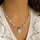 Collar corto con cuentas de perlas irregulares, cristal facetado rosa y detalles metálicos plateados. Incluye un dije ovalado plateado con la imagen de la Virgen Milagrosa.