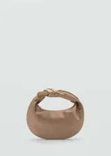Bolso de mano color beige de tejido satinado con asa superior con nudo decorativo. Tiene cierre de cremallera, forro interior y asa de cadena desmontable.