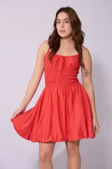 Vestido corto celeste con breteles finos, escote fruncido con lazo y falda con corte globo.