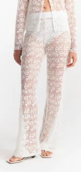 Pantalón calado negro de encaje con diseño floral, corte palazzo y cintura alta.