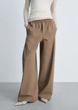 Pantalón wideleg color marrón claro, con cintura elástica, tiro medio, sin cierre, dos bolsillos laterales, estilo jogger y forro interior.