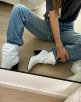 Botines de cuero vacuno color blanco, con punta fina y taco geométrico negro.