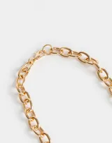 Collar corto dorado con cadena de eslabones gruesos y dije de corazón inflado.