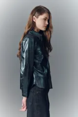 Camisa entallada de cuero ovino verde metalizado, con cuello camisero y botones a presión con logo.