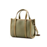 Cartera tipo tote chica color verde, confeccionada en cuero sintético graneado. Tiene doble asa corta y correa larga regulable y extraíble. El acceso es con cierre y cuenta con bolsillos internos.