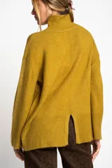 Polera color crema de tejido de punto, con cuello alto y mangas largas.