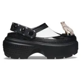 Zueco negro con plataforma exagerada y parte superior brillante. Tiene detalle de cuello blanco moldeado y correa de tobillo con tachuelas en forma de cúpula. Incluye adornos dimensionales como Thing y el violonchelo negro de Wednesday.