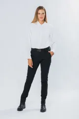 Pantalón de gabardina gris oscuro, corte skinny, con bolsillos delanteros y traseros. Se ajusta a la cintura con cinturón de cuero marrón con hebilla dorada.